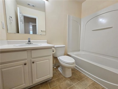 Bathroom with bathing tub / shower combination, vanity, and light tile patterned flooring