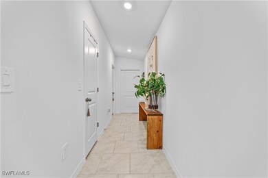 Corridor with baseboards, light tile patterned flo