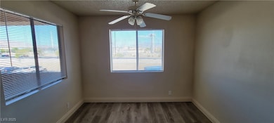 Spare room with wood finished floors, a textured c