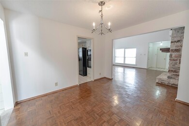 Unfurnished room with a chandelier and baseboards