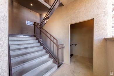 Stairway with concrete floors, a textured wall, and a towering ceiling