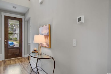 Foyer featuring visible vents, baseboards, wood fi