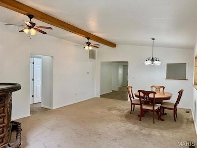 Dining area featuring light carpet, a chandelier, and ceiling fan