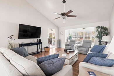 Living room with wood finished floors, high vaulte