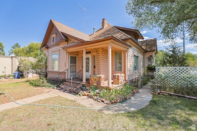 View of front of house featuring a porch, a front lawn, a chimney, and roof with shingles