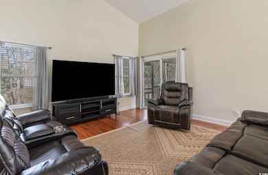 Living area featuring baseboards, high vaulted cei