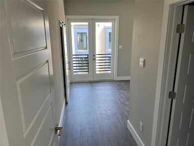 Hall with wood finished floors, baseboards, and fr