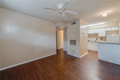 Unfurnished living room featuring a textured ceili
