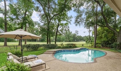 This backyard features a serene pool surrounded by