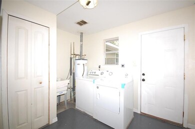 Laundry room, door leads to back stairs, water hea