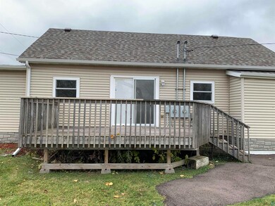 Back of property with a wooden deck and a lawn