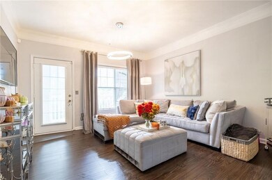 Living area with crown molding and dark wood-type flooring