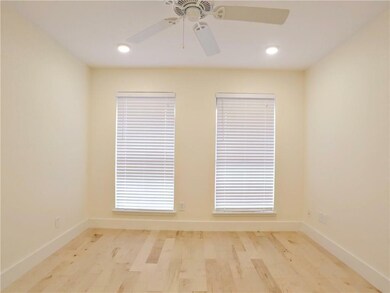 Empty room with ceiling fan, wood finished floors