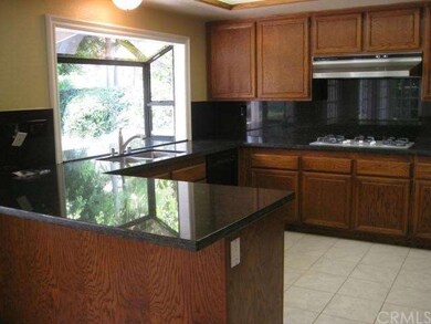 Spacious kitchen with rich wood cabinetry, granite