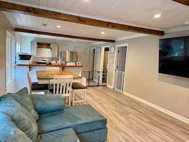Living area with beam ceiling, light wood finished
