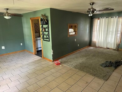 Unfurnished living room featuring light tile patte