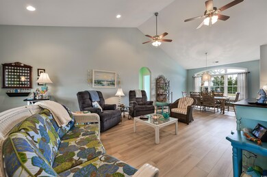 Living room with ceiling fan with notable chandeli