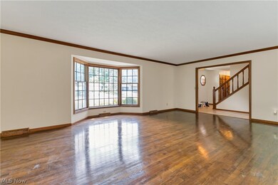 Spare room featuring ornamental molding and hardwood / wood-style floors