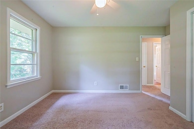 Spare room with carpet, a ceiling fan, and baseboards