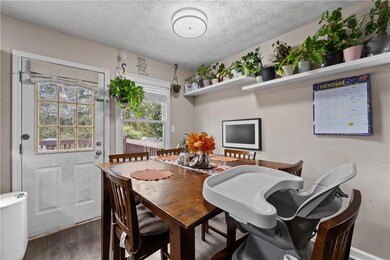 Dining area with a textured ceiling and wood finished floors