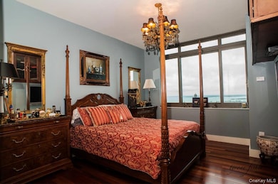 Bedroom featuring dark wood-style flooring and a chandelier