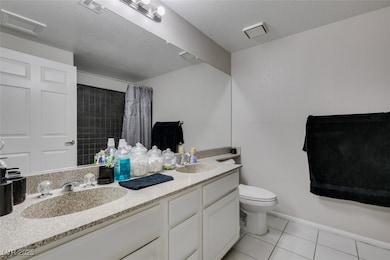 Bathroom with double vanity, a shower with curtain