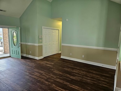 Foyer with high vaulted ceiling and dark wood-style flooring
