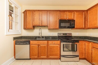 Kitchen featuring sink, dark stone counters, appli