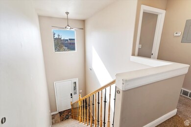 Stairway with electric panel, a ceiling fan, and a high ceiling