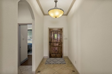 Entryway featuring arched walkways, crown molding