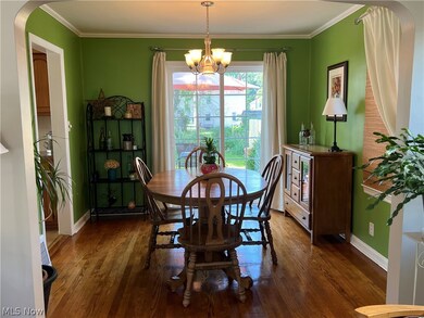 Dining space, oak hardwood flooring, crown molding, and an inviting chandelier