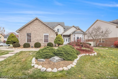 View of front of home featuring a front yard, brick siding, and roof with shingles