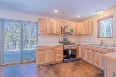 Kitchen with light brown cabinets, stainless steel