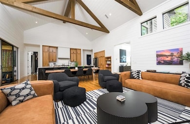 Living room with light wood-style floors, beam cei