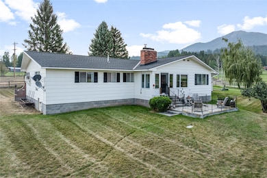 Back of property featuring a chimney, roof with shingles, and a mountain view