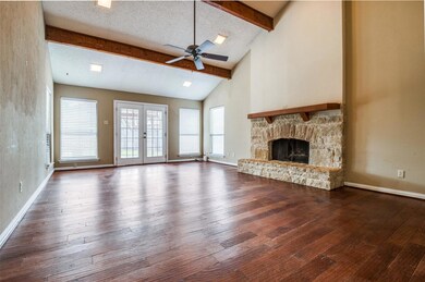 Unfurnished living room with beamed ceiling, hardw