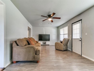 Living area featuring light wood-style floors and ceiling fan