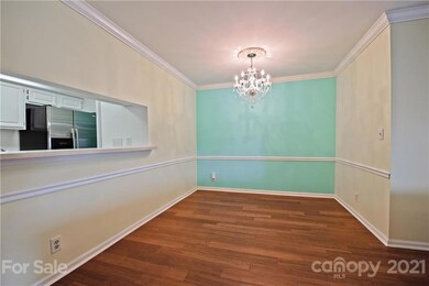 Dining Room features crown molding, custom chandelier, eat in bar area & bamboo floors!