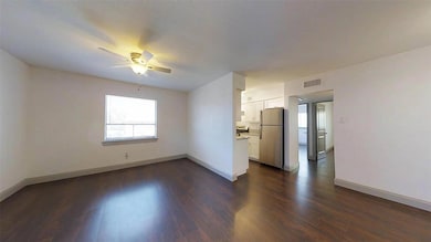 Unfurnished room with ceiling fan and dark hardwoo