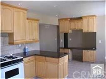 Kitchen with remodeled cabinets, gas stove, dining