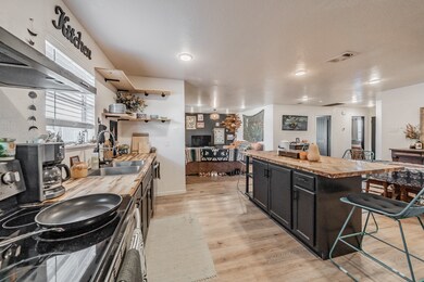 Kitchen with wood counters, a breakfast bar, electric range, extractor fan, and light wood-style flooring