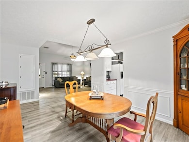 Dining room with light wood finished floors, wains