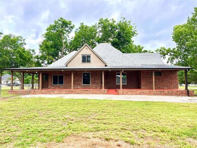 Farmhouse featuring a porch, a front lawn, a shingled roof, and brick siding