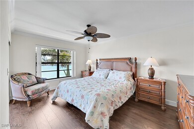 Bedroom with wood finished floors, crown molding,