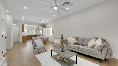 Living room with light wood-style floors, recessed lighting, and a ceiling fan