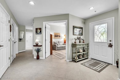 Foyer entrance with light tile patterned flooring and recessed lighting
