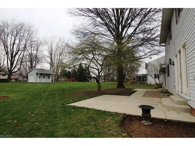 Rear view of home shows backyard, patios and shed.