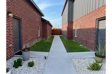 View of side of home featuring brick siding, board and batten siding, and fence