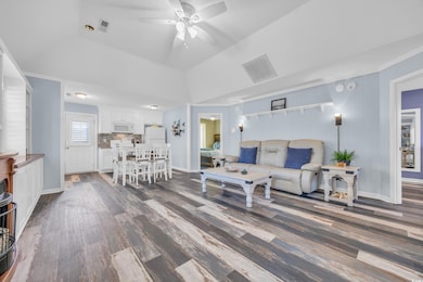 Living room with ceiling fan, a tray ceiling, and 