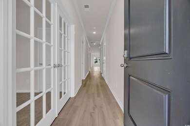Hallway with light wood-style flooring, baseboards